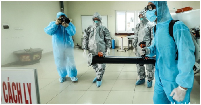 Nhân viên y tế phun khử khuẩn tại khu vực có người nhiễm Covid-19 (chụp màn hình trên báo Tuổi Trẻ).