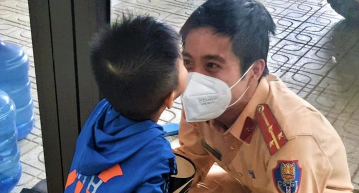 Cậu bé thơm cha qua lớp cửa kính (ảnh chụp màn hình Dân Trí).